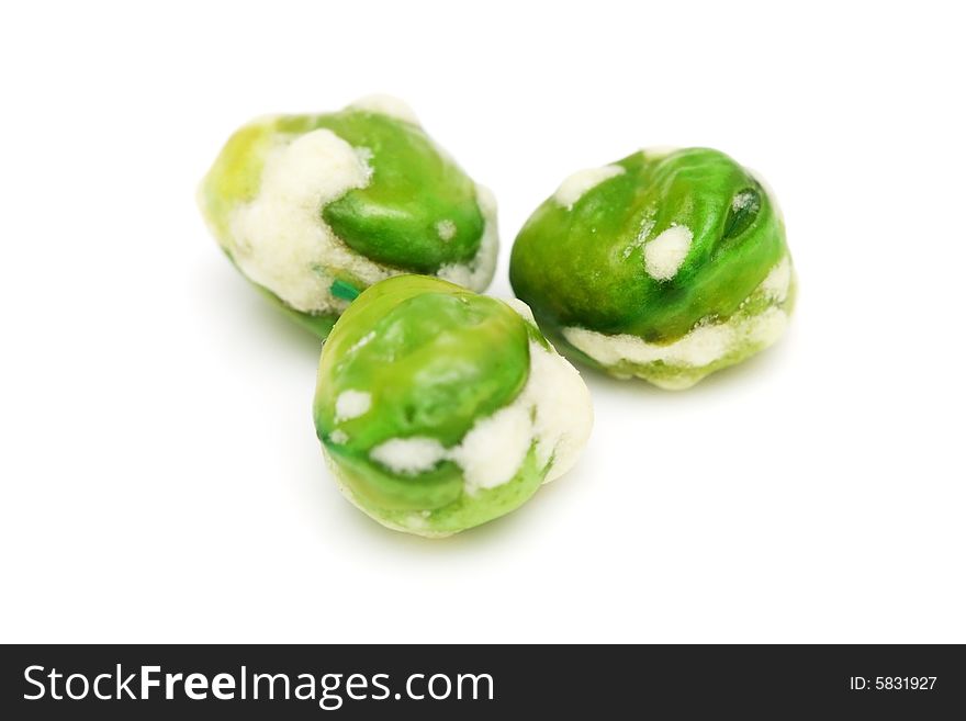 Macro shot of three wasabi coated green peas.