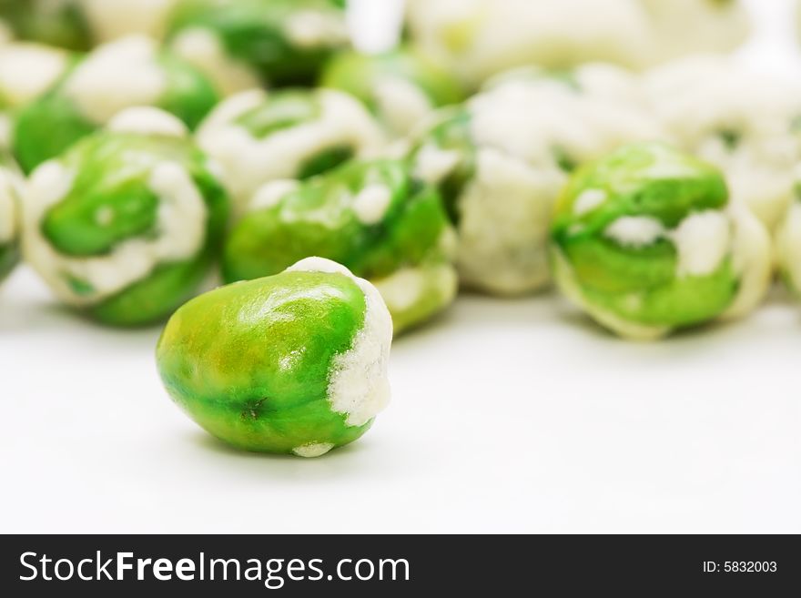 Close up shot of wasabi coated green peas.
