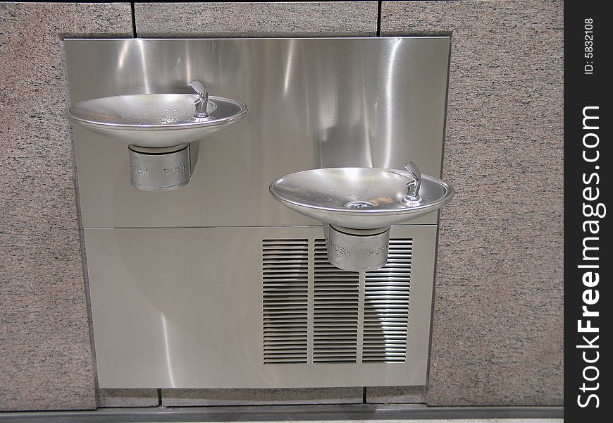 Silver double water coolers on a wall