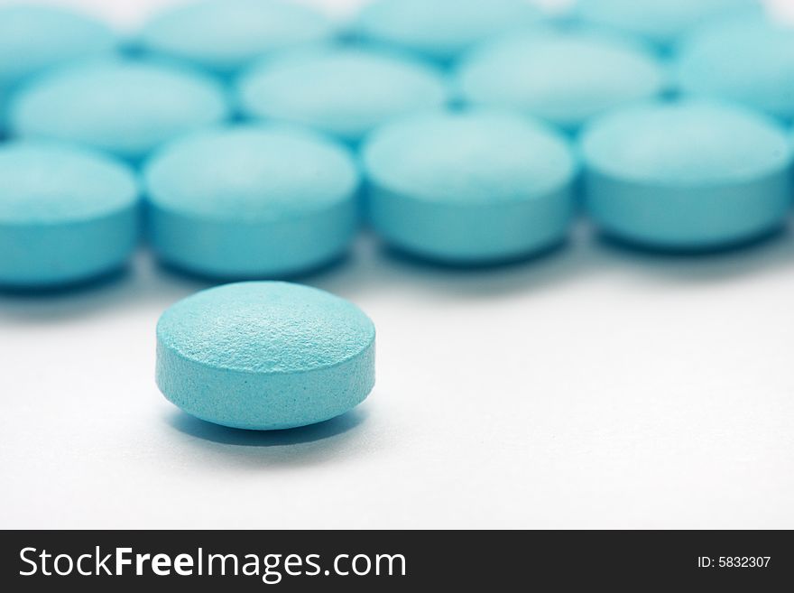 Close up shot of a pile blue pills.