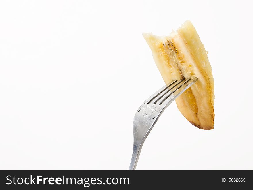 Sliced banana with bite on fork. Sliced banana with bite on fork