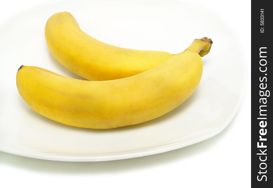 A bunch of fresh bananas on white plate and isolated on white background