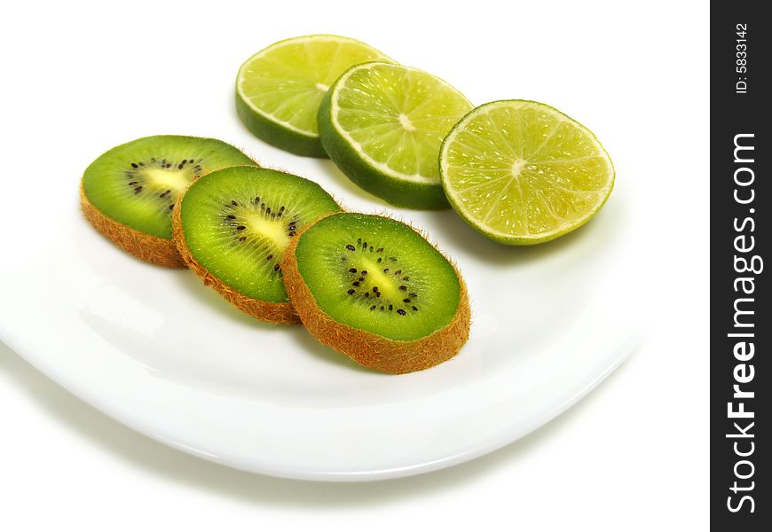 Sliced fresh kiwi and lime on white plate and isolated on white background. Sliced fresh kiwi and lime on white plate and isolated on white background