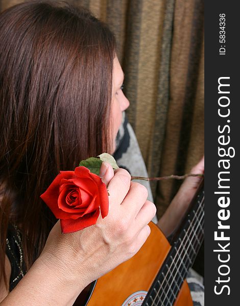 Brunette female holding a guitar, FOCUS on rose. Brunette female holding a guitar, FOCUS on rose