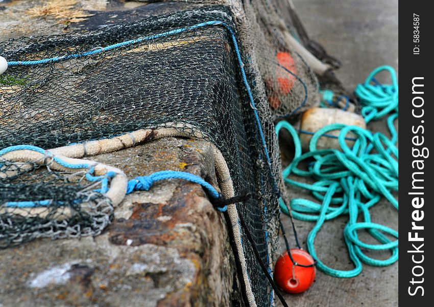 Fishing nets with floats drying on a wall in the harbour. Fishing nets with floats drying on a wall in the harbour