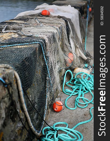 Fishing nets with floats drying on a wall in the harbour. Fishing nets with floats drying on a wall in the harbour