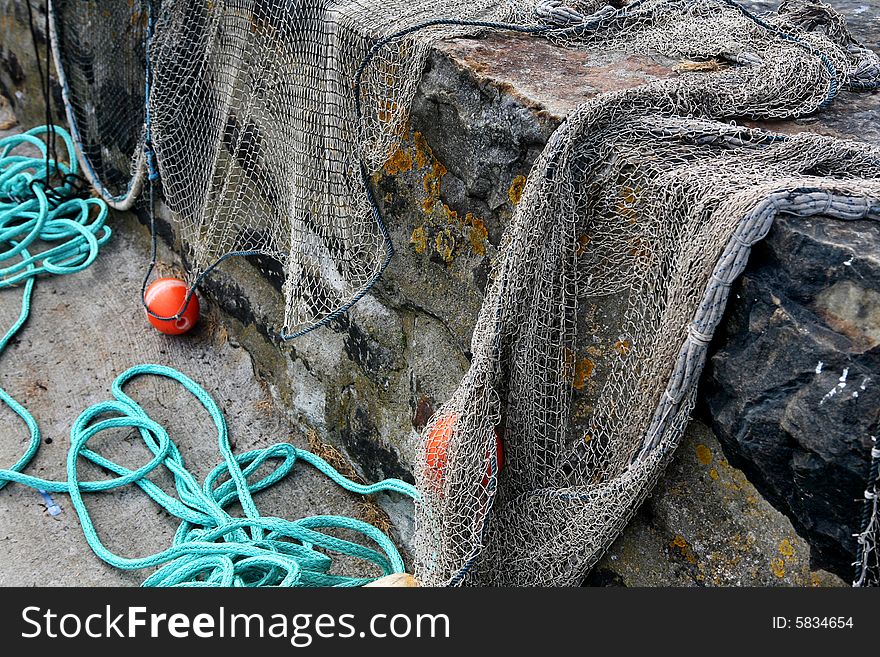 Fishing nets with floats drying on a wall in the harbour. Fishing nets with floats drying on a wall in the harbour