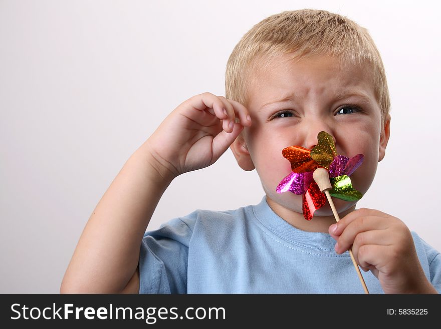 Toddler playing with a wind toy, but face upset. Toddler playing with a wind toy, but face upset