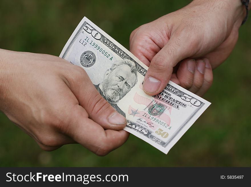 Two manÂ´s hands with fifty dollars. Two manÂ´s hands with fifty dollars
