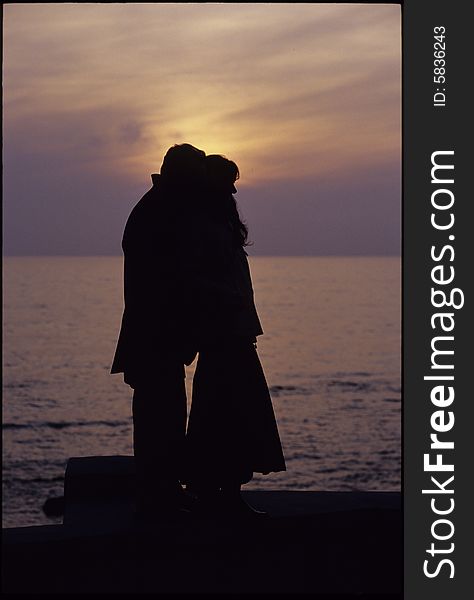 A man and a woman stay together in front of the sea sunset. A man and a woman stay together in front of the sea sunset