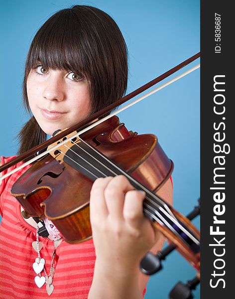 A smiling girl with big hazel eyes playing her viola. A smiling girl with big hazel eyes playing her viola.