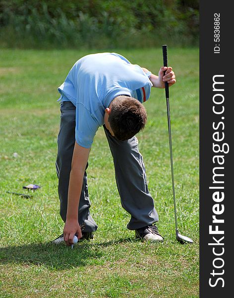 Shot of a boy getting ready to play a round of golf. Shot of a boy getting ready to play a round of golf