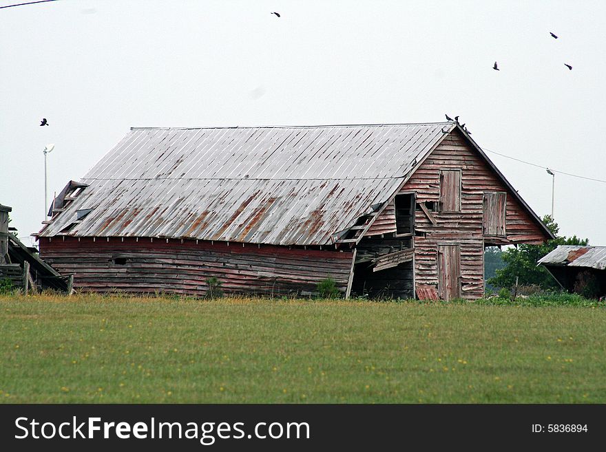 A barn that is falling apart in a field. A barn that is falling apart in a field