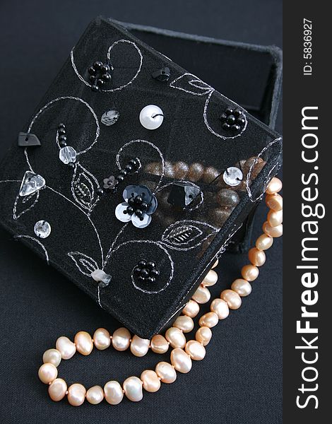 Black embroidered jewelery box with a string of pearls