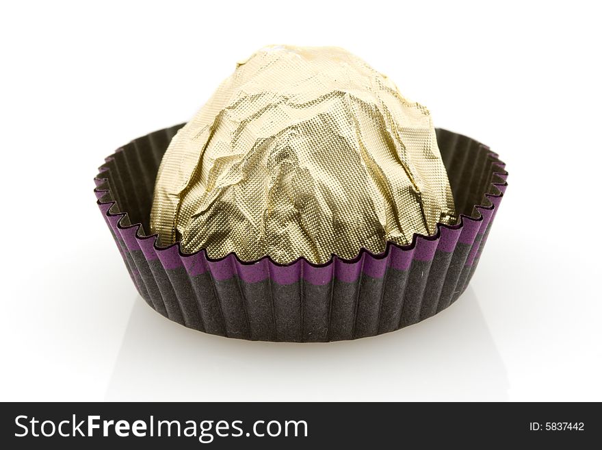 Sweet choco candy wrapped in golden foil, white background. Sweet choco candy wrapped in golden foil, white background