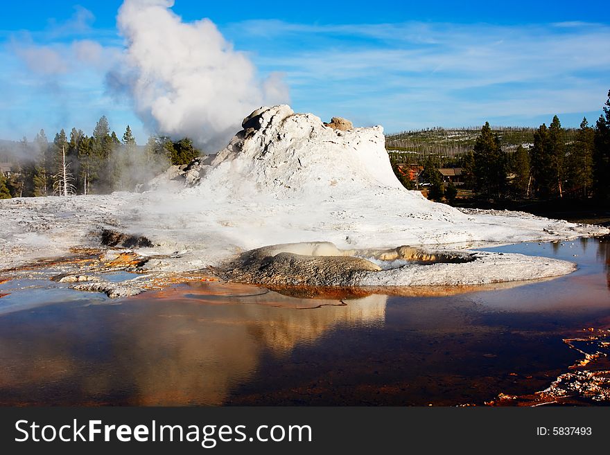 Castle Geyser (of the Upper Geyser Basin) reflecting in a pool - Yellowstone National Park.