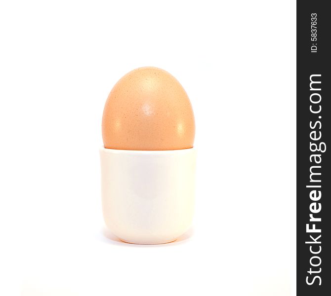 An egg in a cup on a solid white background