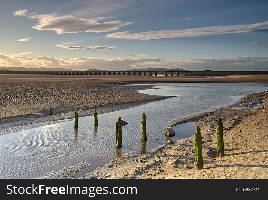 Wooden posts on the sandy shore at  Arnside, Cumbria, England. Wooden posts on the sandy shore at  Arnside, Cumbria, England