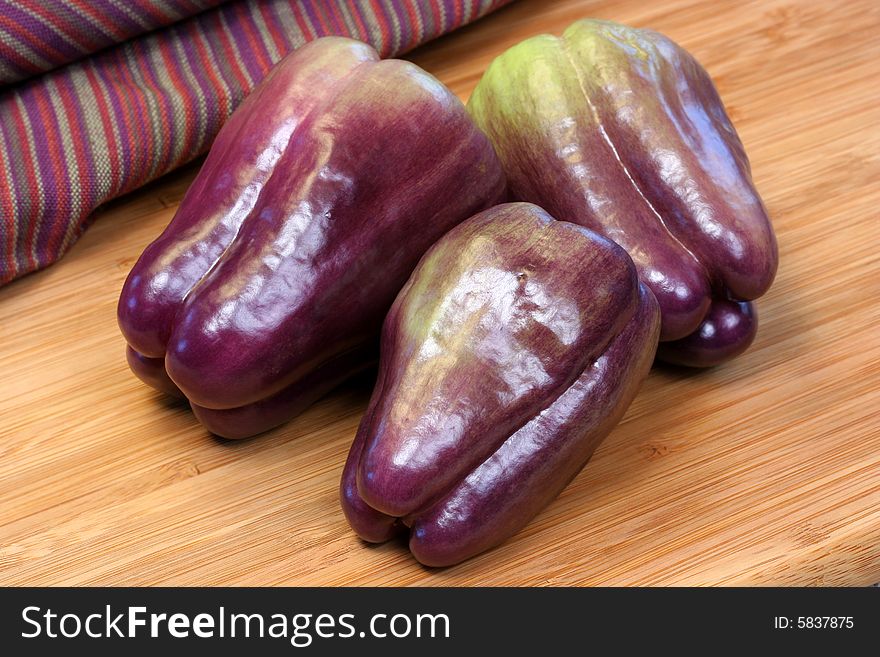 Three beautiful purple bell peppers, whole and ripe. Three beautiful purple bell peppers, whole and ripe.