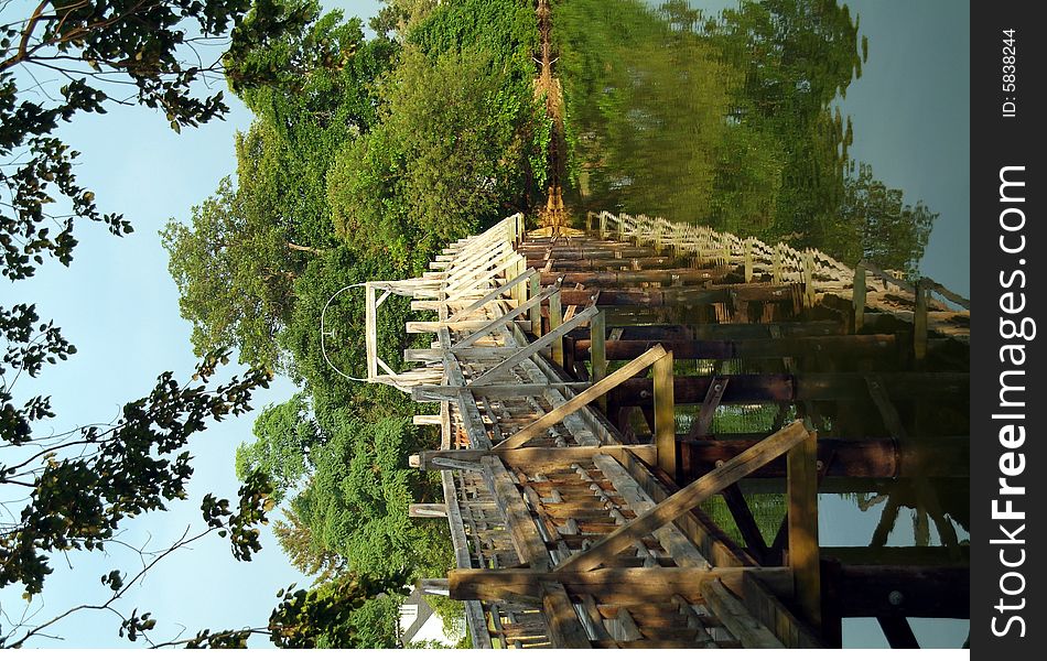 Wooden bridge over river in sunlight