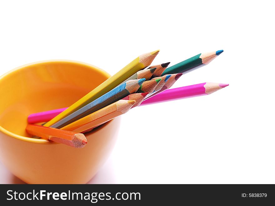 Colorful pencils in the yellow cup isolated on white background