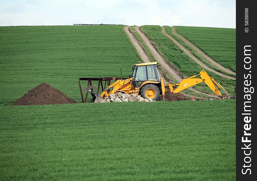 Excavator in the green field