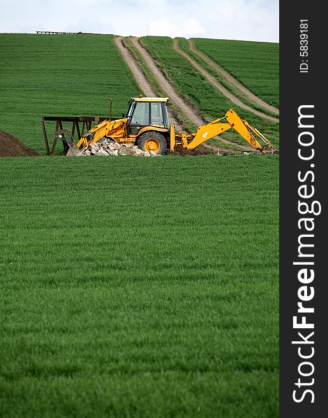 Excavator in the green field