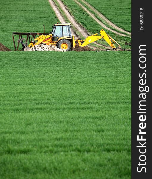 Excavator in the green field