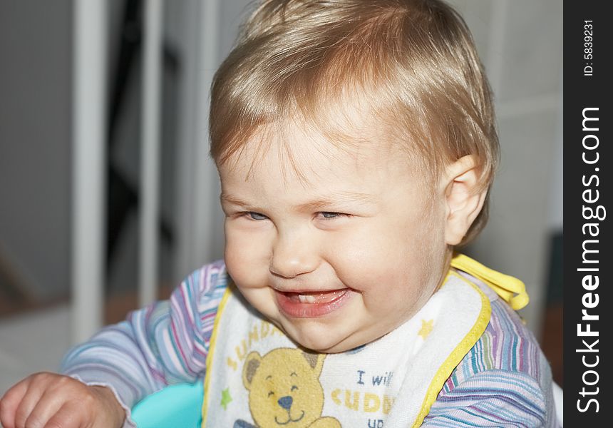 Happy baby laughing with two front teeth showing and eyes full of expression