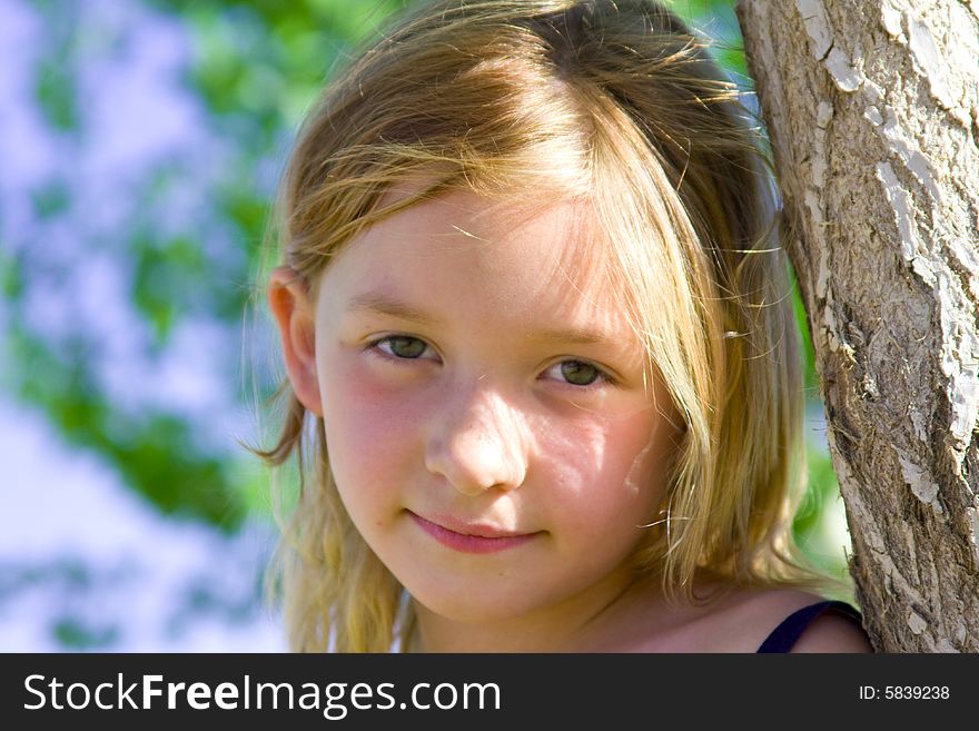 Smiling six year old girl with the sun shining in her hair.