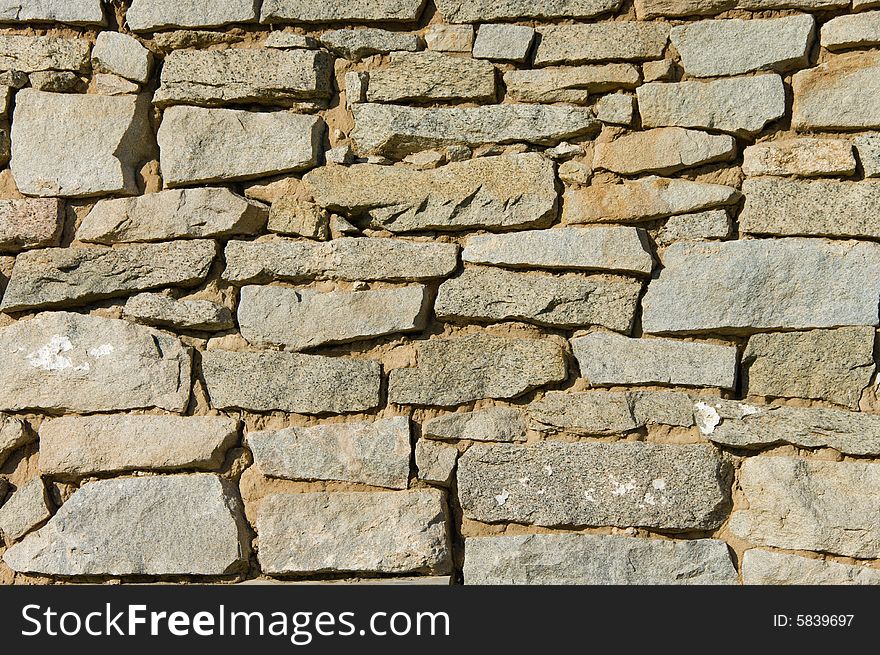 Old stone wall background shot in direct sunlight