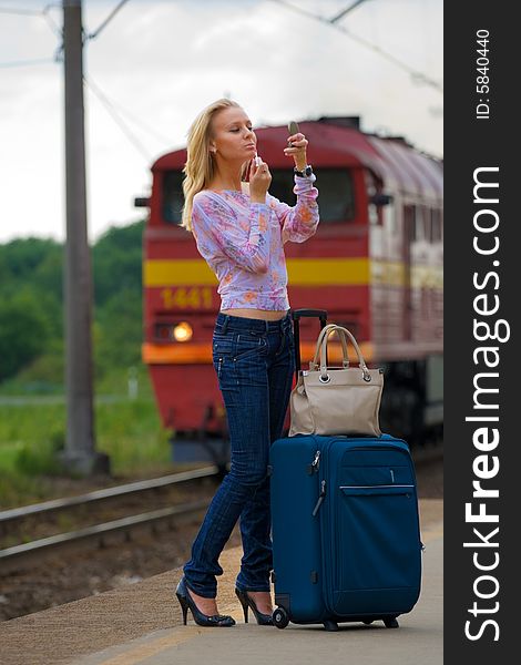 Beautiful young lady with big suitcase waiting for a train. Beautiful young lady with big suitcase waiting for a train