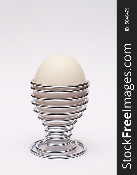 Single egg in a stainless steel eggcup. Single egg in a stainless steel eggcup.
