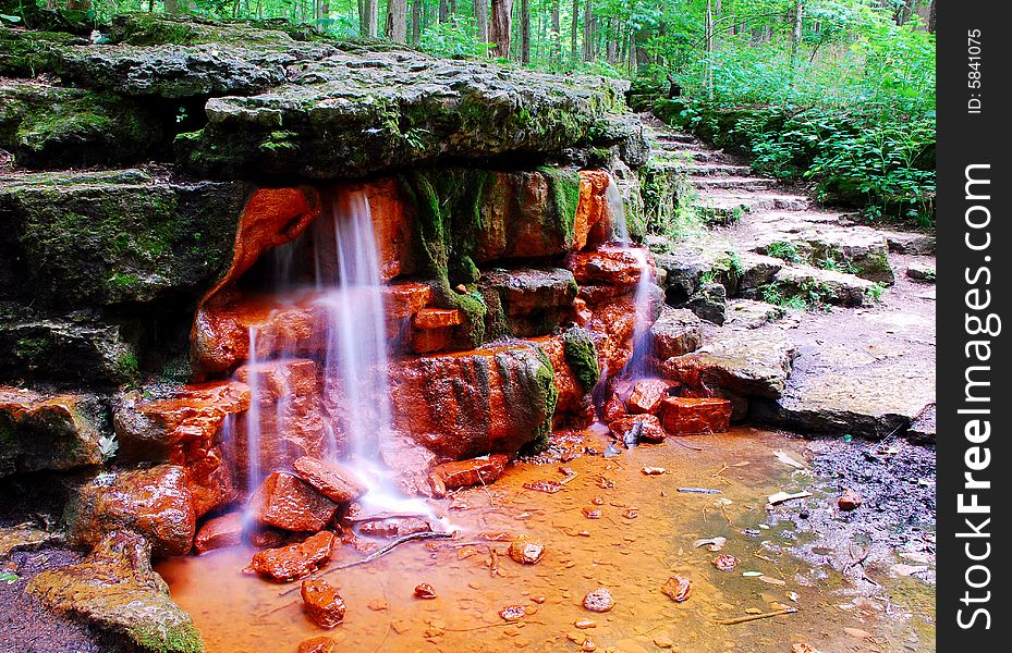 This is a shot of a small waterfall. There is a lot of green, rock steps and ever so small a cliff in this image. The spring is called Yellow Spring. This is a shot of a small waterfall. There is a lot of green, rock steps and ever so small a cliff in this image. The spring is called Yellow Spring.