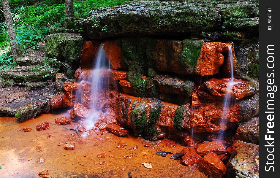 This is a shot of a small waterfall. There is a lot of green, rock steps and ever so small a cliff in this image. The spring is called Yellow Spring. This is a shot of a small waterfall. There is a lot of green, rock steps and ever so small a cliff in this image. The spring is called Yellow Spring.