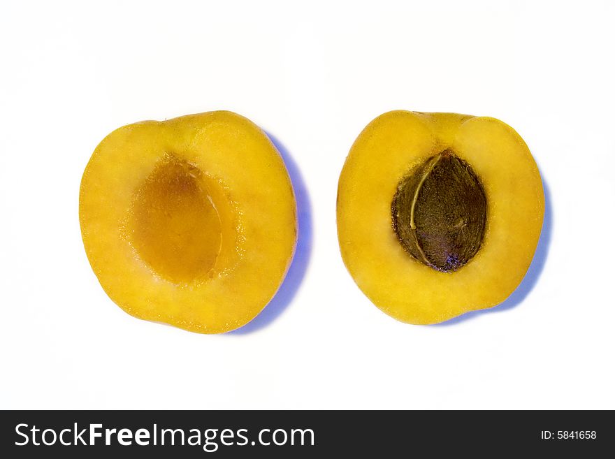 Two halves of an apricot on white background