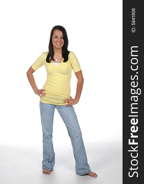 Pretty teen standing with hands on her hips in yellow shirt. Pretty teen standing with hands on her hips in yellow shirt