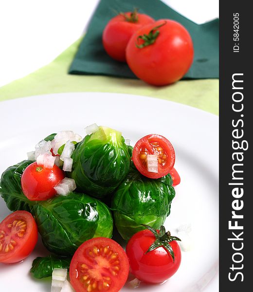 Fresh organic salad of Brussel sprouts and cherry tomatoes, on white background