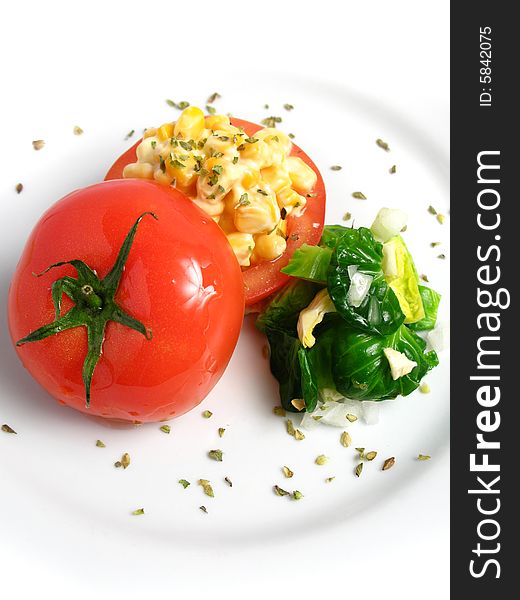 Tomato Stuffed with corn and 	
mayonnaise on a white dish