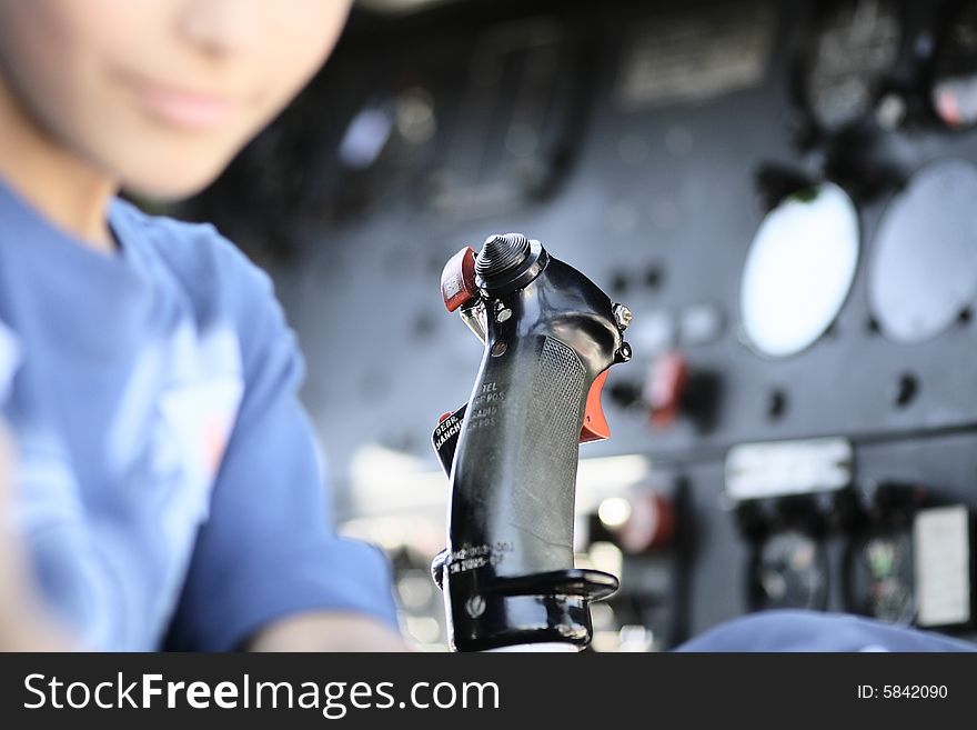 close up of a joystick controller at the main board of an airplane with an unrecognizing young face on the left. close up of a joystick controller at the main board of an airplane with an unrecognizing young face on the left