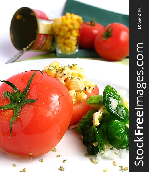 Tomato Stuffed with corn and 	
mayonnaise on a white dish