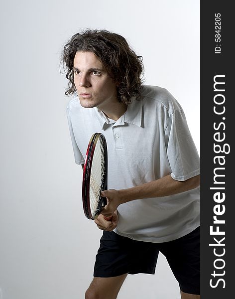 A young male athlete holding a tennis racket. Vertically framed shot. A young male athlete holding a tennis racket. Vertically framed shot.