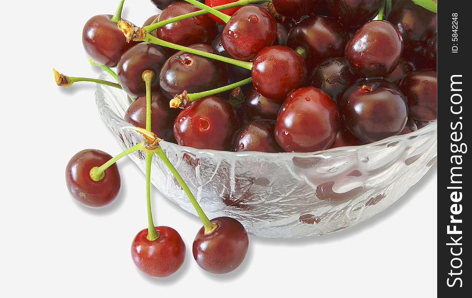 Ripe berries of a cherry of red color in a glass vase.