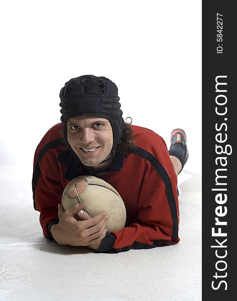 Rugby player holding a fooball with a happy look on his face. Vertically framed photograph. Rugby player holding a fooball with a happy look on his face. Vertically framed photograph