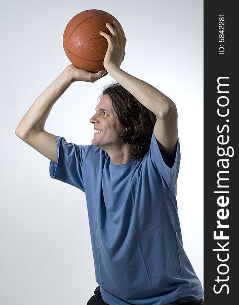Man shooting a basketball with a smile on his face. Vertically framed photograph. Man shooting a basketball with a smile on his face. Vertically framed photograph.