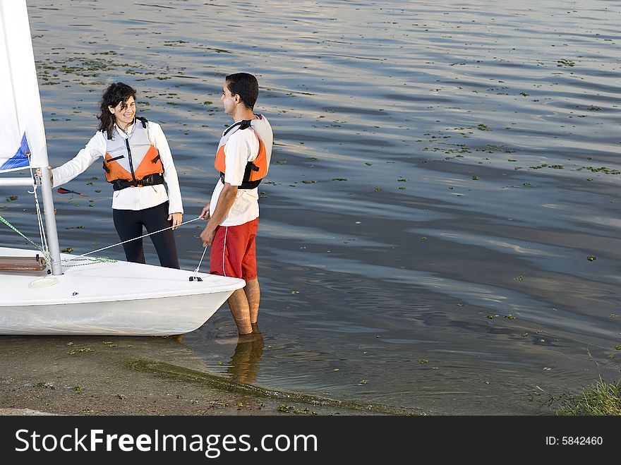 Couple Next to Sailboat on Water - Horizontal