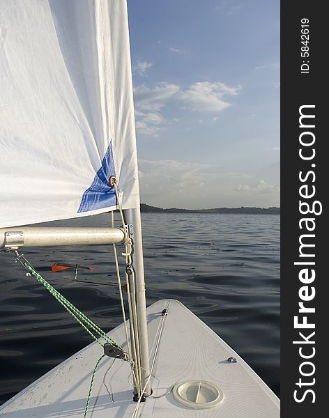 View of a lake from the bow of the sailboat.  Vertically framed shot. View of a lake from the bow of the sailboat.  Vertically framed shot.