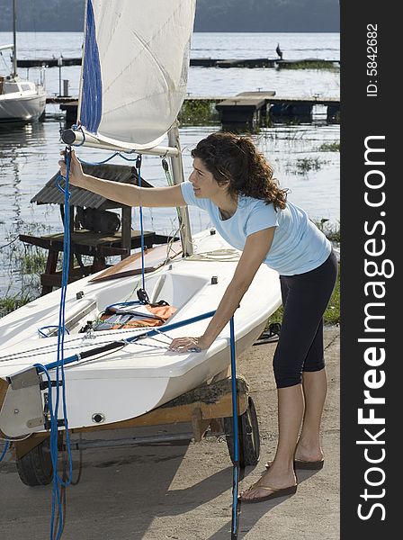 Woman Fixing Sail On Sailboat - Vertical