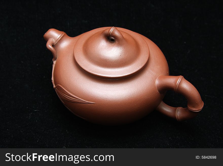 An teapot on black background.