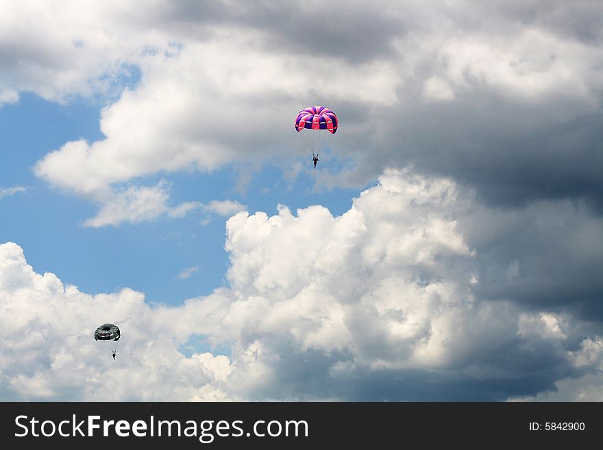 Flying parachutes on background with blue sky and clouds. Flying parachutes on background with blue sky and clouds